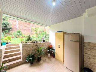 Sala de estar com vista para o jardim através de uma grande janela.