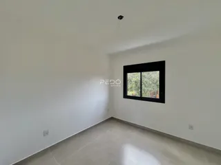 Ambiente interno de uma sala com paredes brancas e piso de cerâmica.