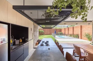 Vista de uma área de estar moderna com acesso a um quintal com piscina.
