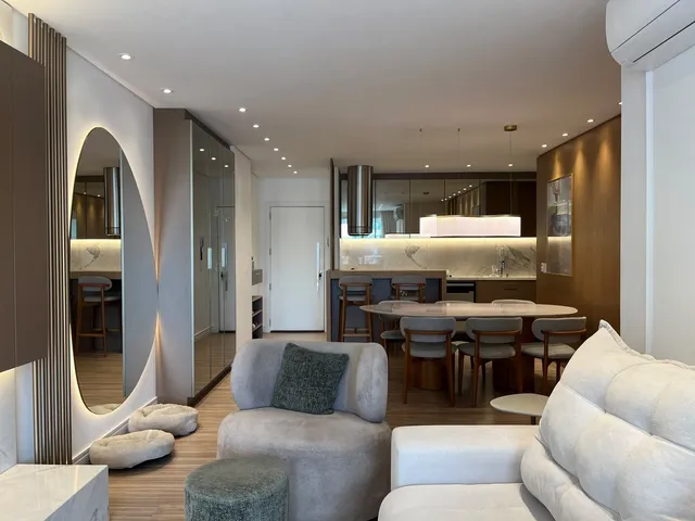 Sala de estar moderna com sofá e área de jantar integrada.