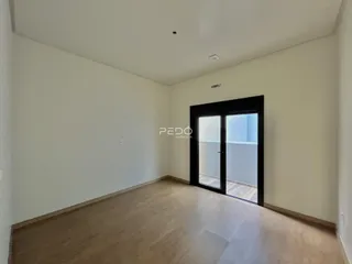 Ambiente interno com piso de madeira clara e paredes brancas.