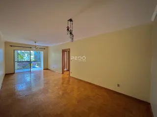Ambiente interno de uma sala com piso de madeira e porta de vidro.