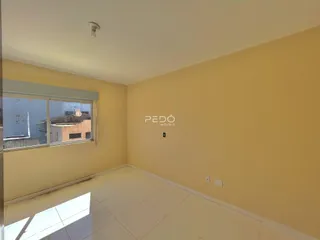 Ambiente interno de uma sala com piso de cerâmica e paredes amarelas claras.