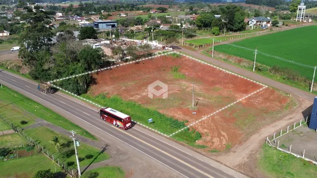 Vista aérea de um terreno vazio com cerca e estrada no Brasil.