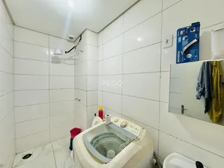 Interior de um banheiro com revestimento de cerâmica branca.