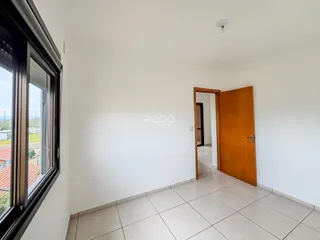 Interior de um ambiente com piso de cerâmica e porta de madeira.
