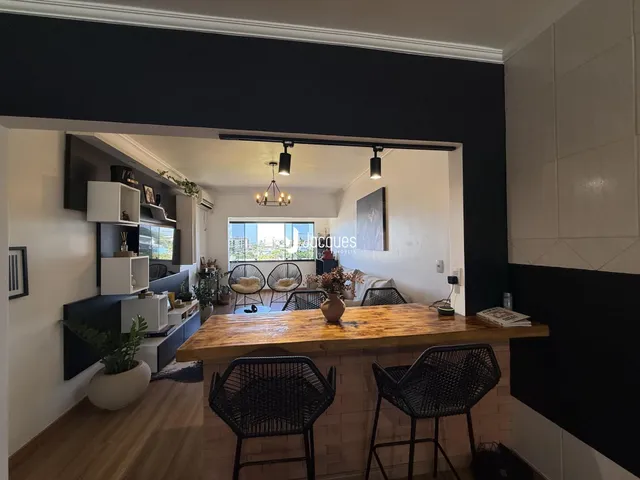 Interior de uma sala de estar com bancada de madeira e vista para uma janela.