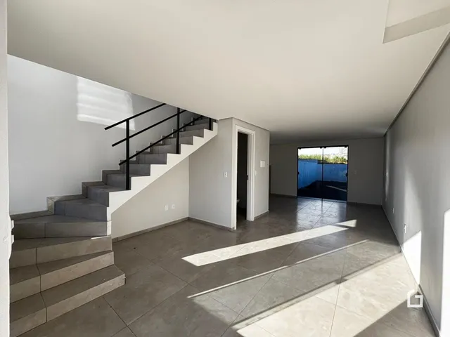 Vista de um hall com escadaria em uma residência.