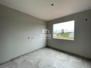 Foto de um cômodo interno com paredes brancas e piso de cerâmica.
