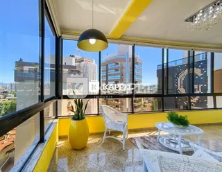 Sala com grandes janelas que proporcionam uma vista da paisagem urbana.
