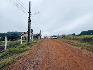 Uma estrada de terra leva a uma propriedade rural na paisagem.