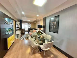 Sala de estar com mesa de jantar de vidro e piso de madeira em um imóvel no Brasil.