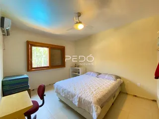 Quarto interno com cama e janela de madeira.
