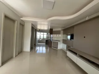 Ambiente interno de uma sala com piso de cerâmica clara e molduras brancas.