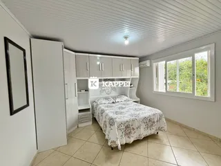 Um quarto com cama e armários brancos e piso de cerâmica.