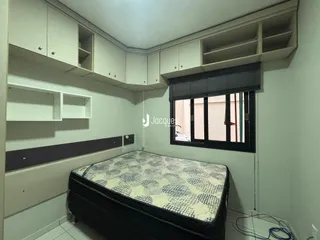Quarto com armários embutidos e cama no interior de uma residência.