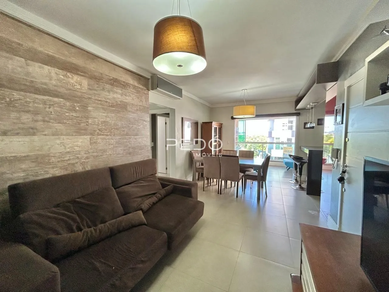 Sala de estar com sofá e mesa de jantar em apartamento.