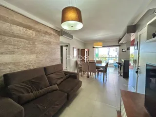 Sala de estar com sofá e mesa de jantar em apartamento.