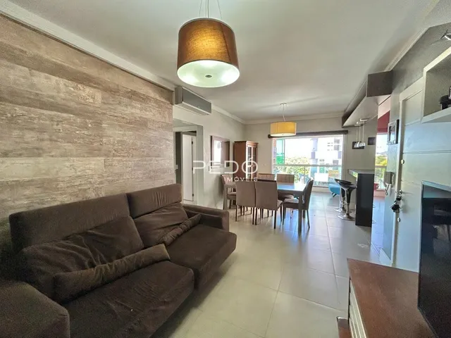 Sala de estar com sofá e mesa de jantar em apartamento.