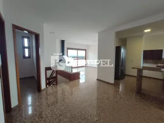 Sala de estar ampla com piso de granito polido e portas de madeira.