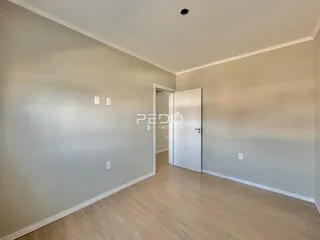 Ambiente interno de uma sala com piso de madeira clara.