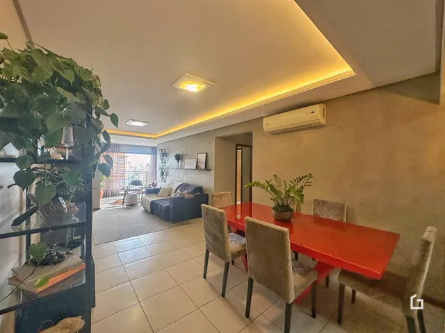 Sala de estar com mesa de jantar e plantas.