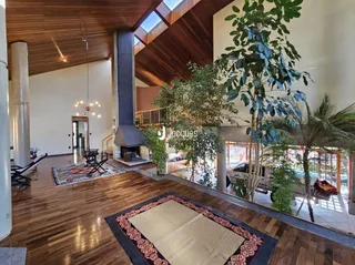 Sala de estar com piso de madeira e teto alto.