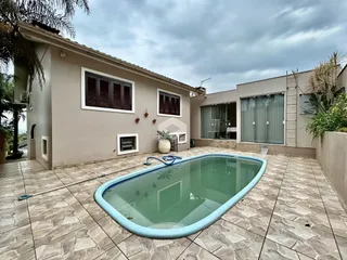 Fachada de casa em Lajeado com piscina e área externa pavimentada.