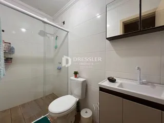 Banheiro com box de vidro e piso cerâmico em Lajeado.