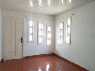 Uma sala interna com paredes brancas e piso de cerâmica.