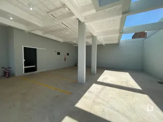 Foto de um espaço interno com piso de concreto e teto branco.