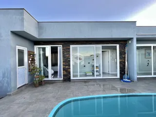 Fachada moderna de uma residência em Lajeado, Brasil, com piscina em primeiro plano.