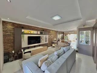 Sala de estar moderna com sofá e parede de destaque em Lajeado.