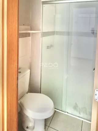 Foto de um banheiro com box de vidro e vaso sanitário.