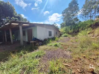 Vista da fachada de uma casa em Lajeado, Brasil, com vegetação ao redor.