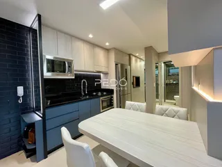 Foto de uma cozinha moderna com armários azuis e mesa de jantar em um imóvel no Brasil.