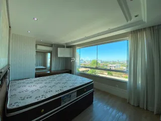 Quarto com vista para a paisagem através de uma grande janela.