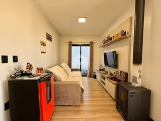 Sala de estar com sofá e piso de madeira clara.