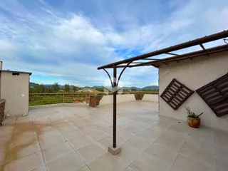 Vista de uma área externa pavimentada com piso de cerâmica e pérgola em Lajeado.