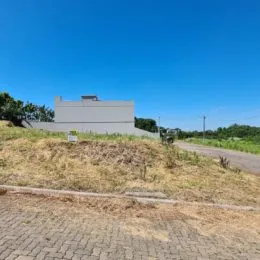 Vista externa de uma área de terreno seca com vegetação rasteira.