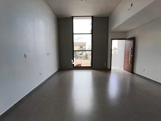 Interior de uma sala com piso de cerâmica e grande janela.
