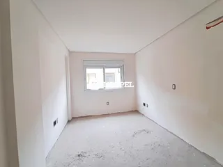 Foto de um cômodo vazio com paredes brancas e piso cru.