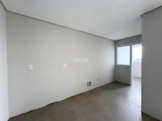 Vista interna de um corredor com paredes brancas e piso de cerâmica.