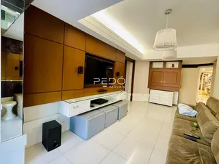 Sala de estar com painel de madeira e piso claro.