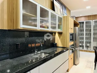 Cozinha moderna com armários de madeira e bancada escura.