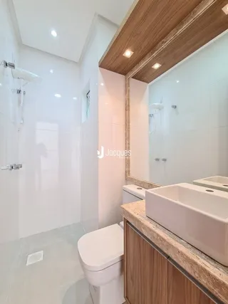 Foto de um banheiro moderno com louças brancas.