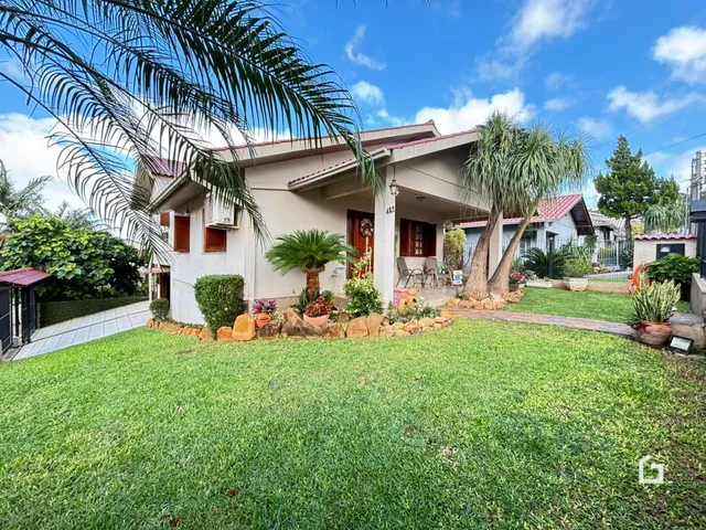 Fachada de uma casa em Lajeado, Brasil com jardim gramado e vegetação.