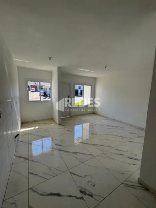 Ambiente interno de uma sala com piso de mármore claro.