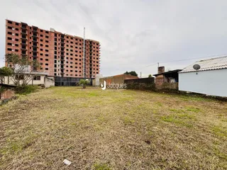 Vista externa de um prédio de tijolos com terreno gramado.