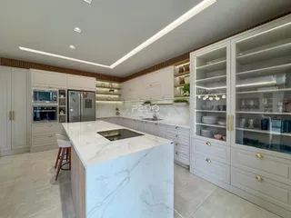 Cozinha moderna com armários brancos e bancadas de mármore na Lajeado.
